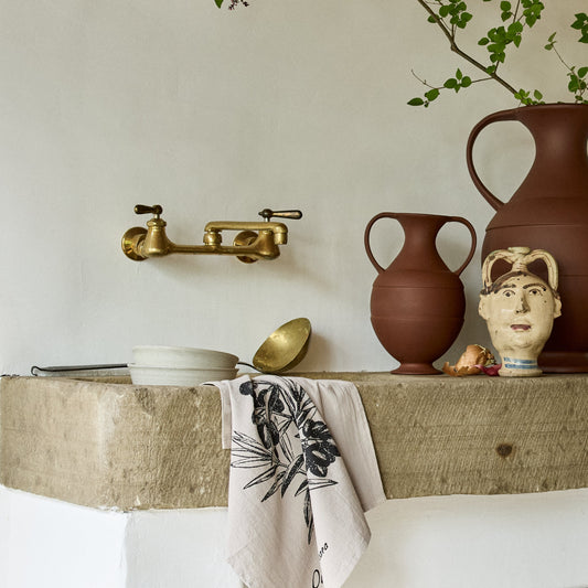 Terra cotta amphora shaped vases on a rustic kitchen countertop