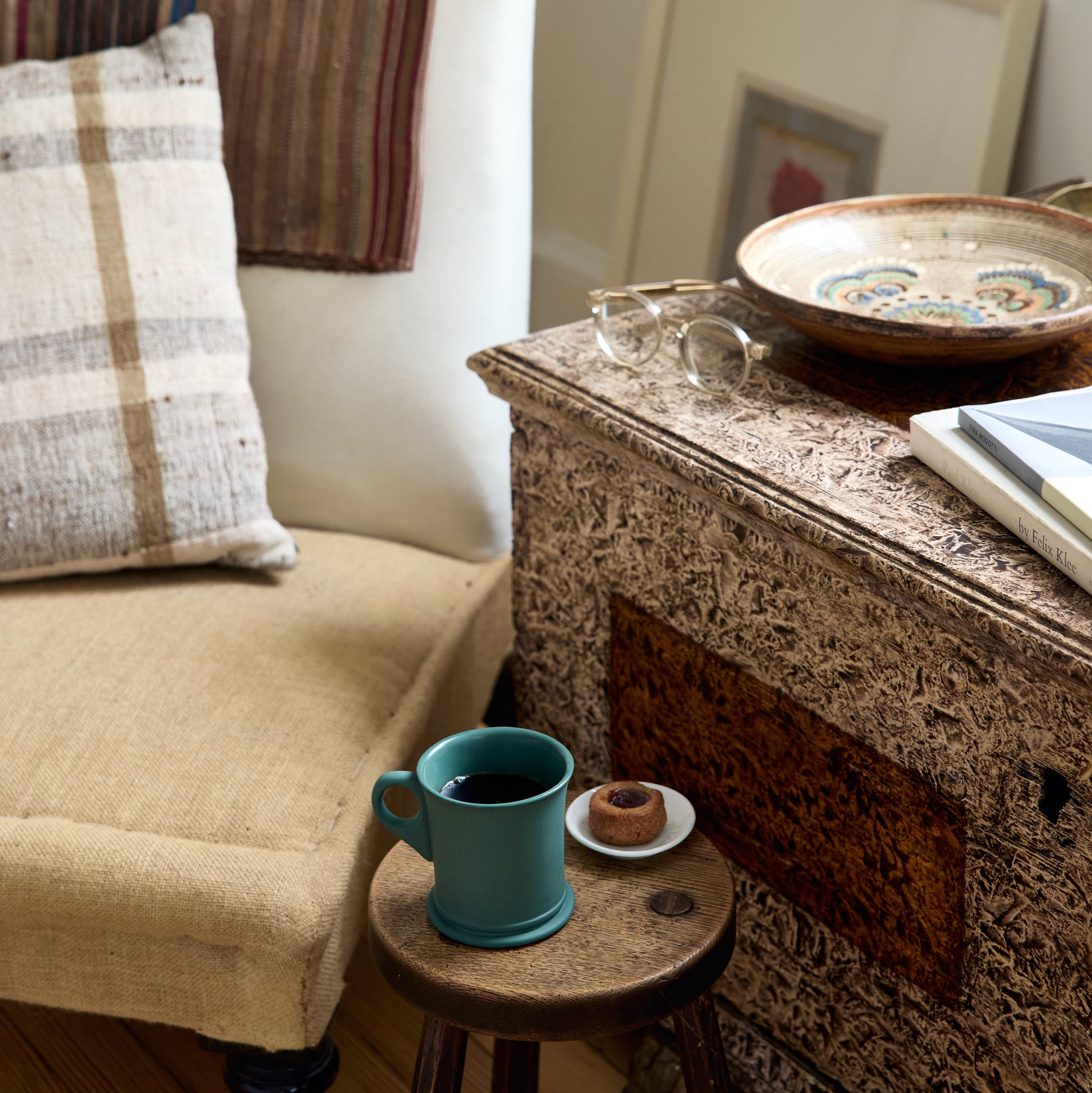 Living room scene with a beige sofa, small table, and decorative items.