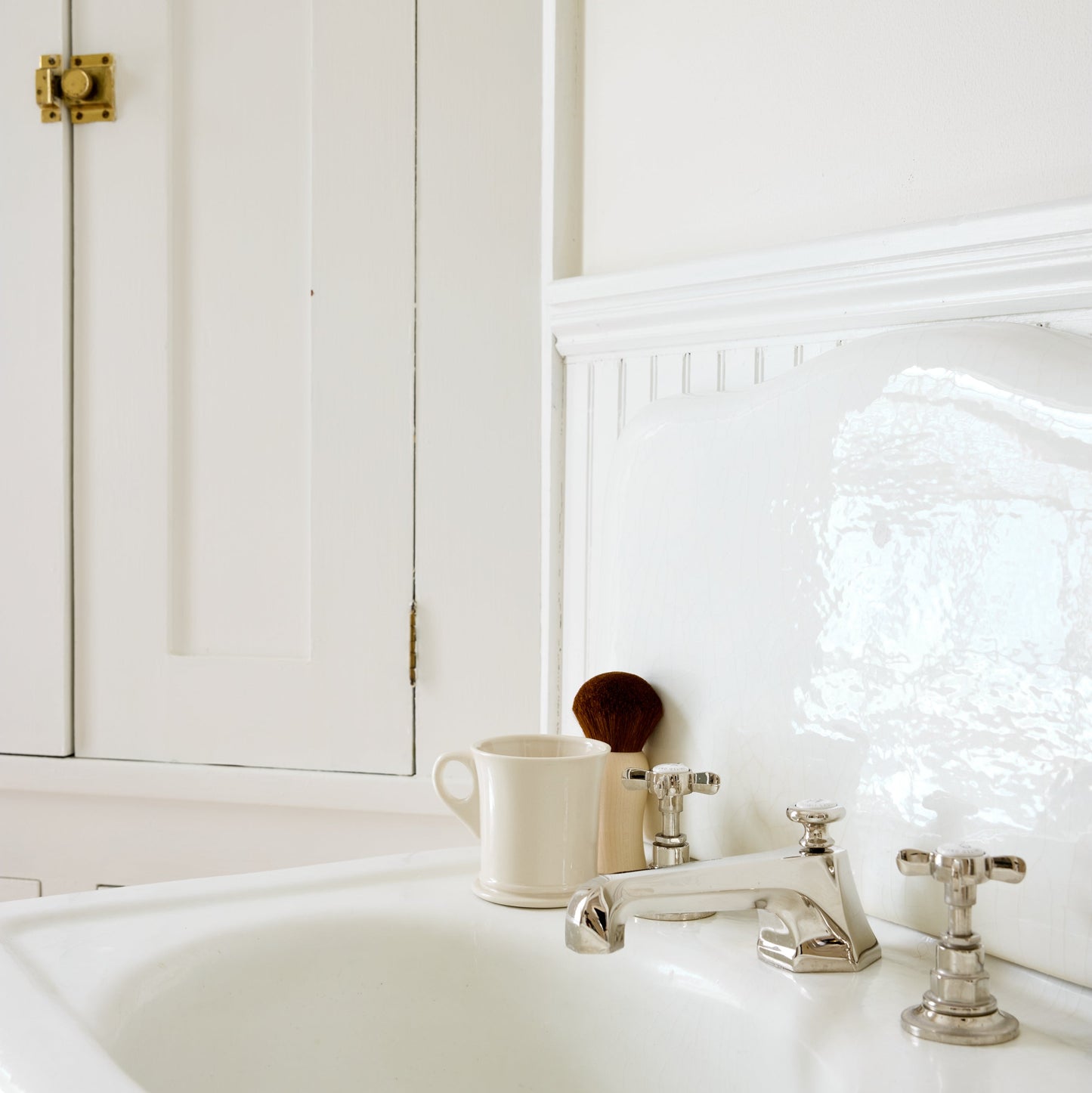 White bathroom sink with silver faucet and mirror reflection